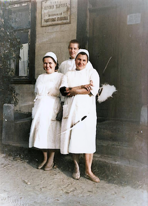 Tanya, working as a nurse, standing in front of the hospital.  She is on the left.